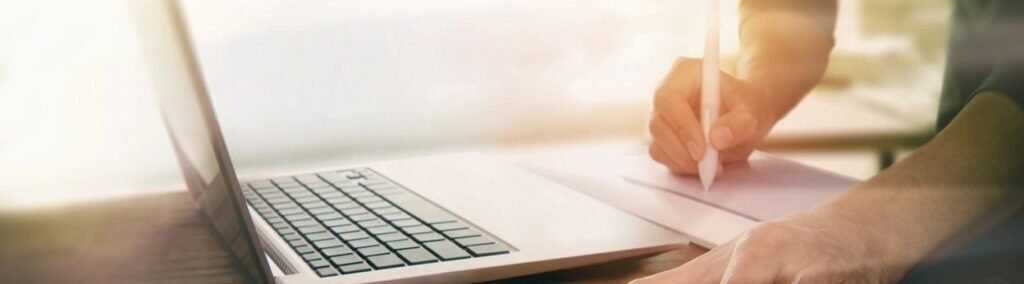 Business person working at a desk with a laptop and ipad